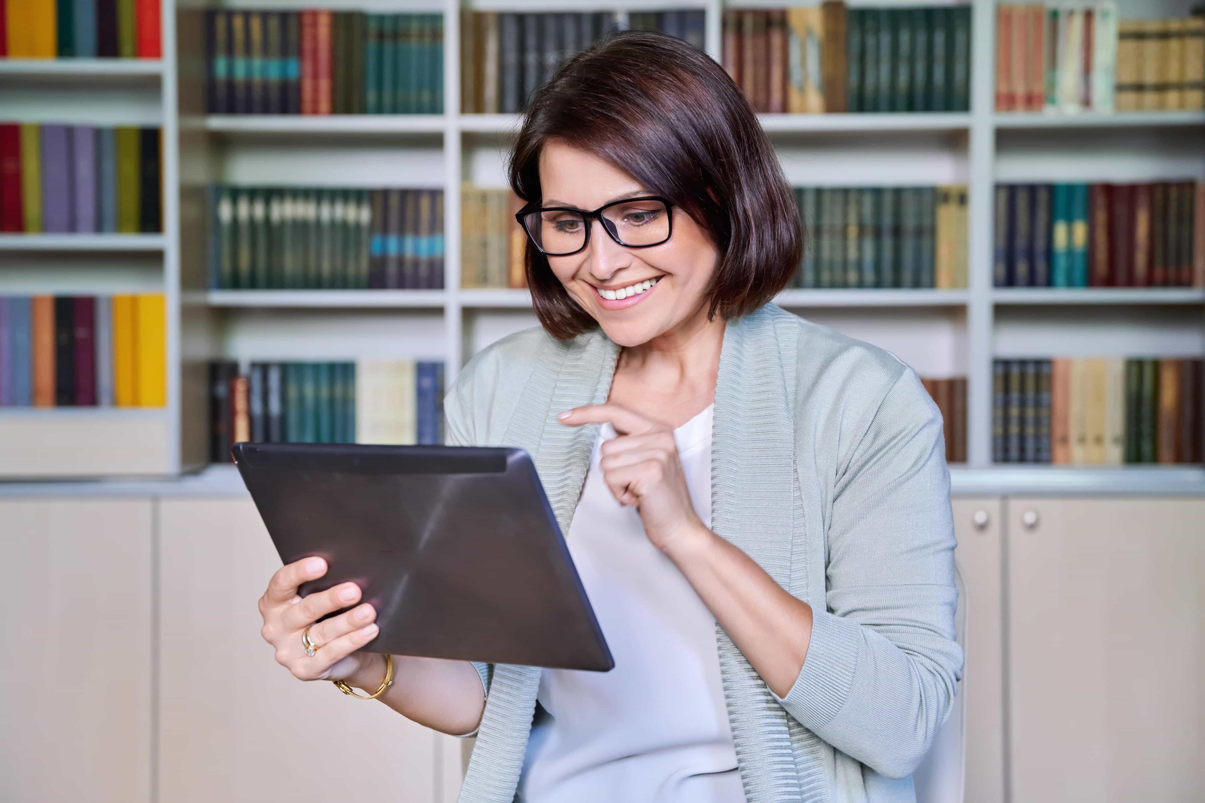 An education consultant works on a tablet to review their client's university application.