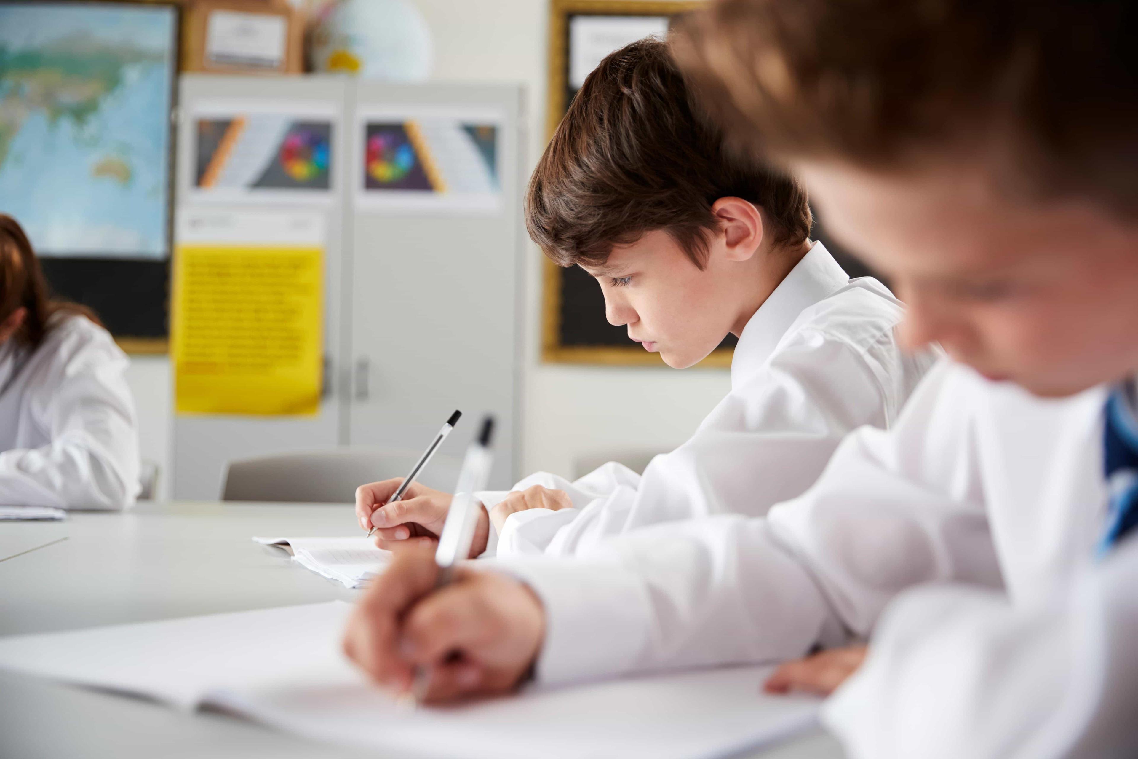 A young student focuses as he completes his school admission exam for an independent senior school.