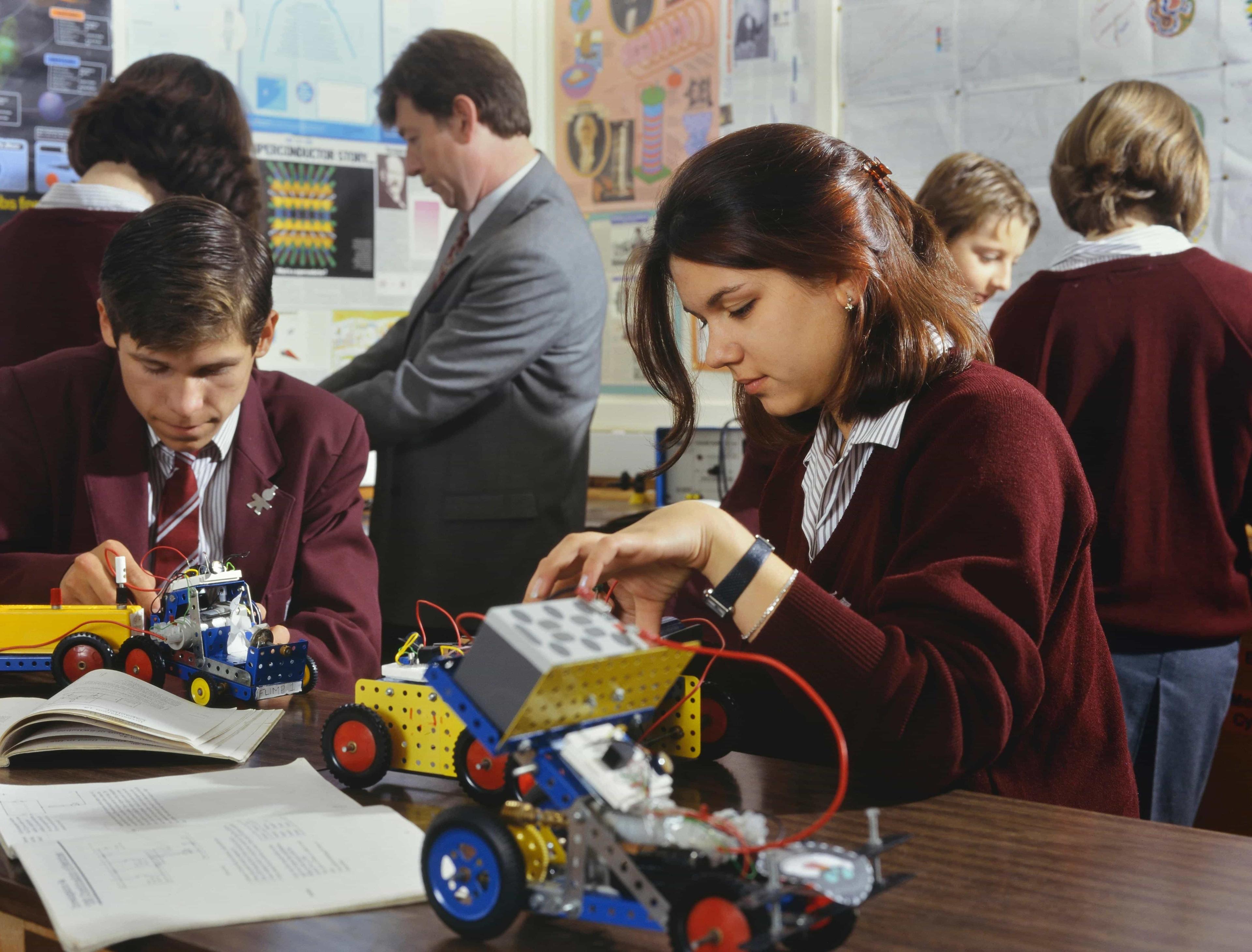 A group of students engaged in a robotics workshop, building and programming robots.