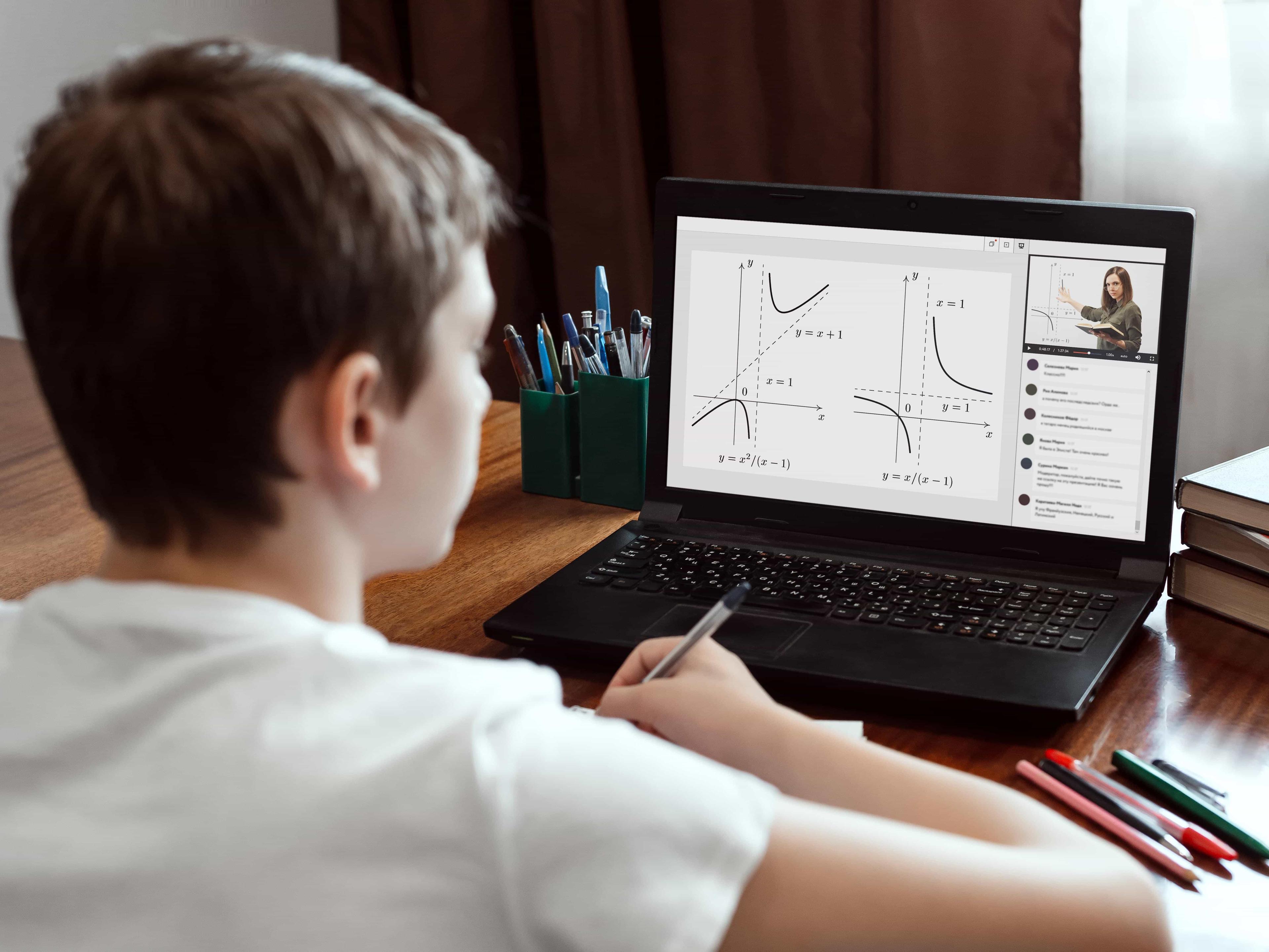 A GCSE student attentively watches his one-to-one oniline tutor through his laptop.