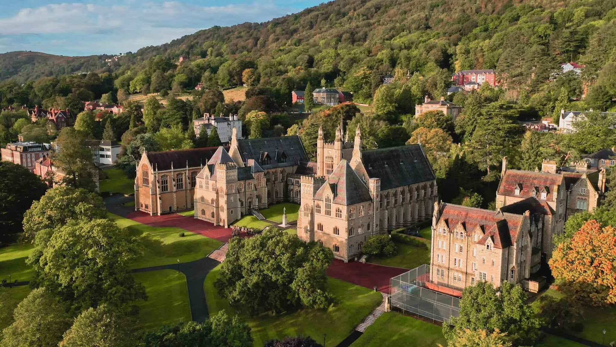 British private school buildings stand amidst trees, creating a picturesque educational setting.
